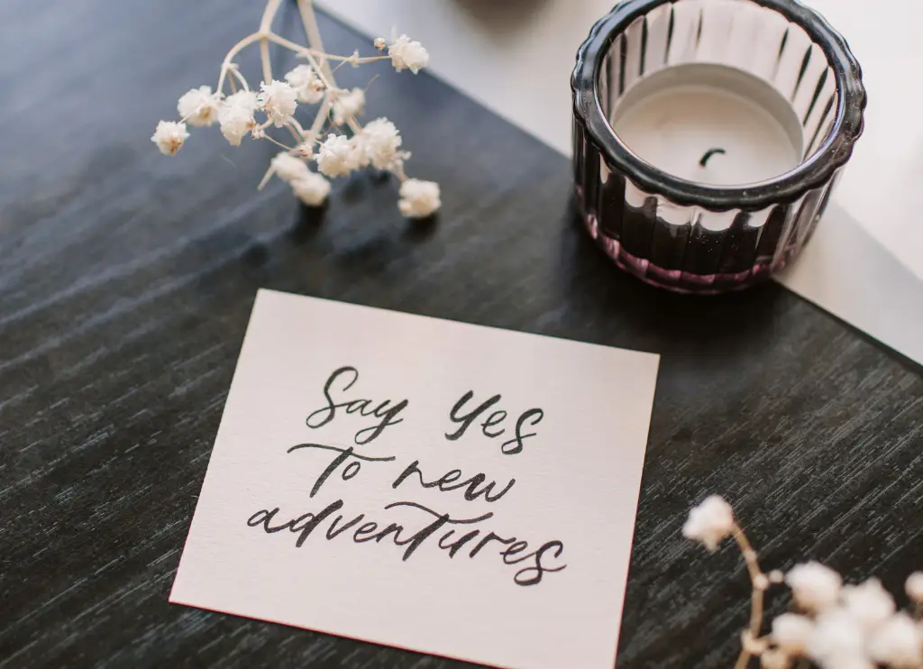 “Post-it su un tavolo con la scritta ‘Say yes to new adventures’, simbolo di incoraggiamento a superare la paura del cambiamento e abbracciare nuove opportunità.”
